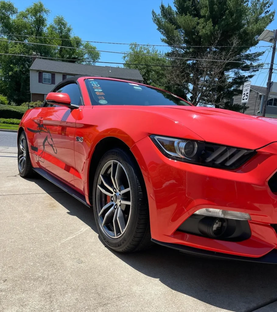 Red car fully detailed and gleaming under the sun
