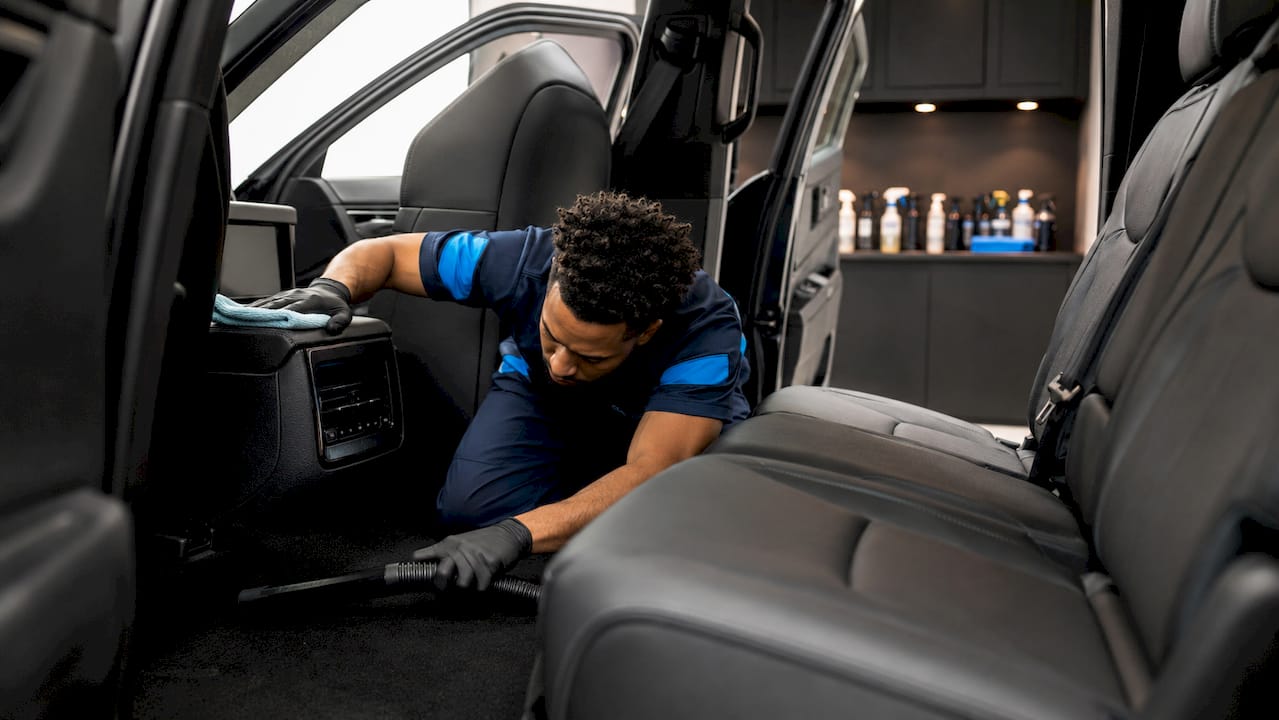Technician detailing car interior in workshop