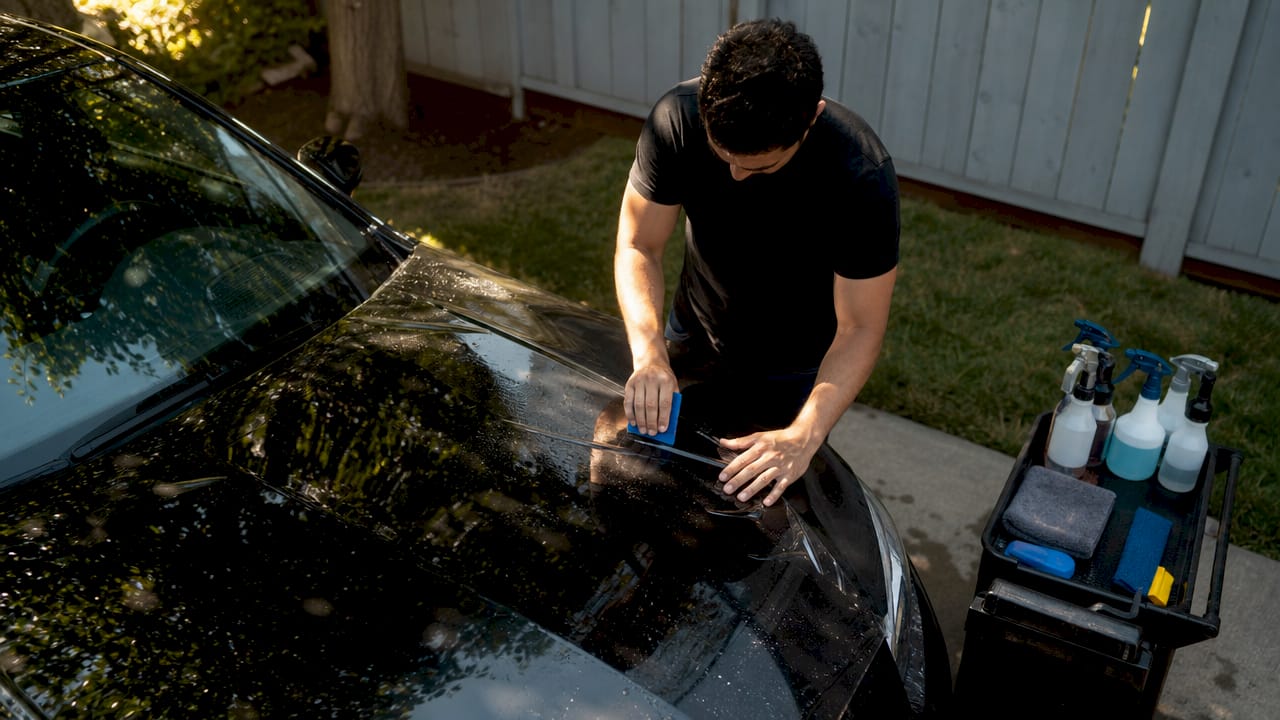 Man applying paint protection film on car