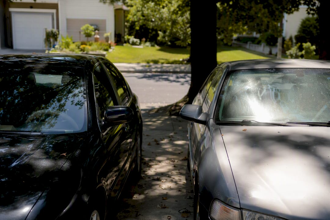 Two parked cars, one shaded one in sun