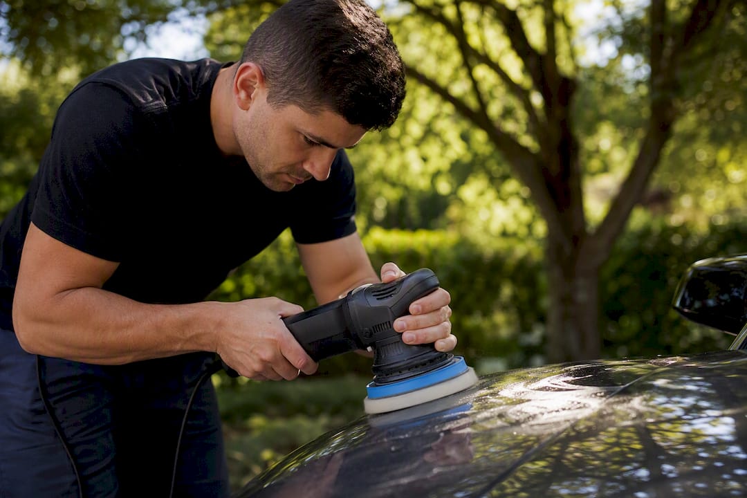 Auto detailer polishing car paint surface