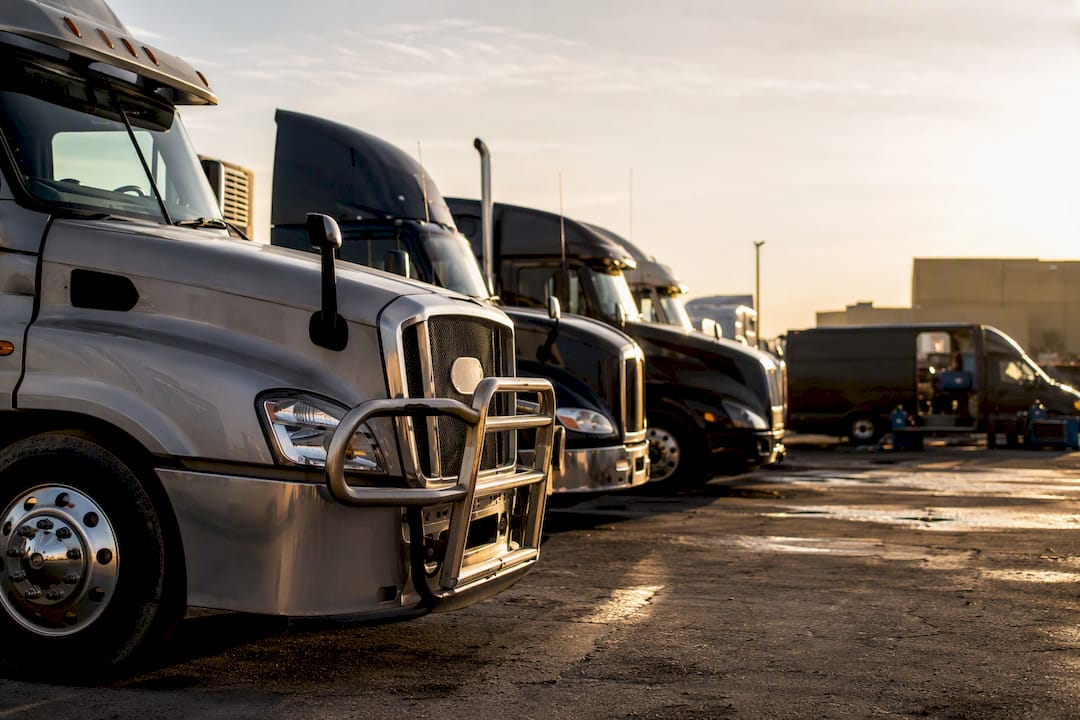 Fleet of semi trucks in industrial yard