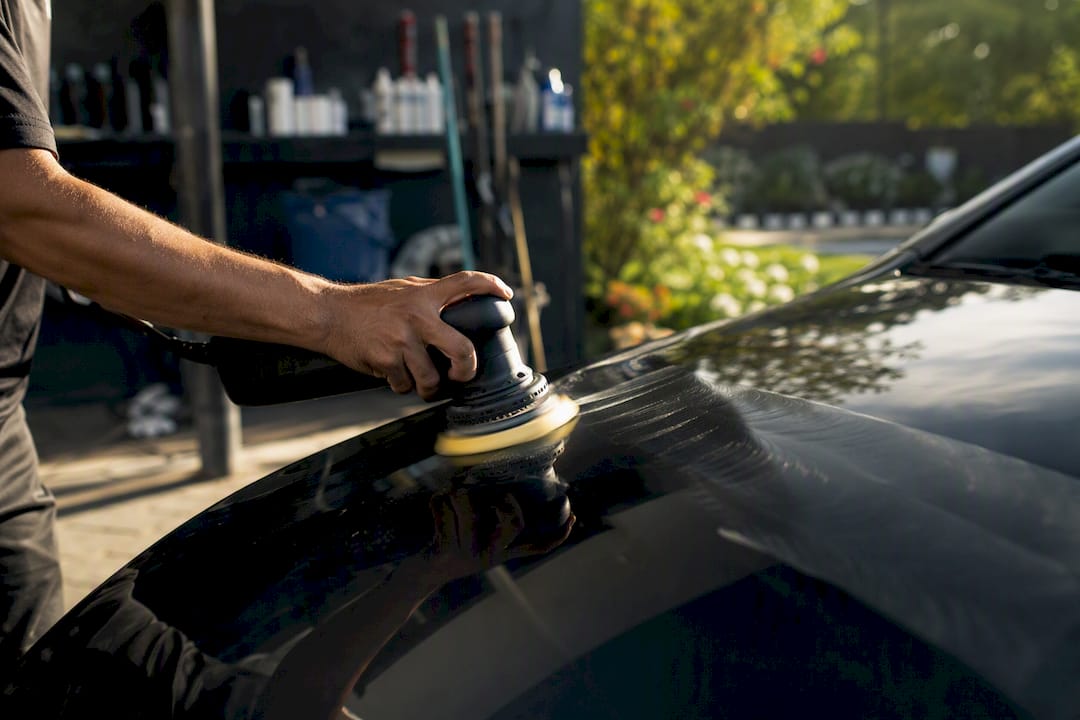 Hand polishing black car paint surface