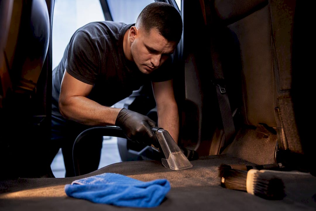 Detailer cleaning vehicle carpet interior