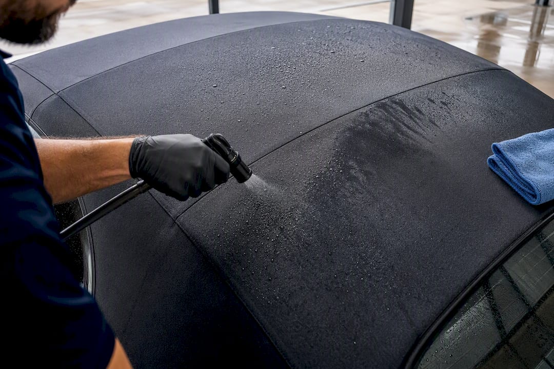Detailer testing water repellency on fabric top