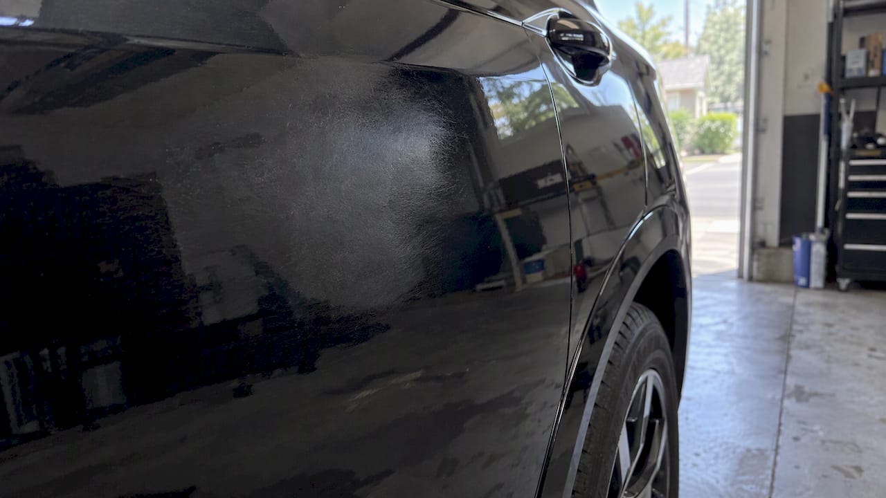 Dull hazy patch beside glossy car paint