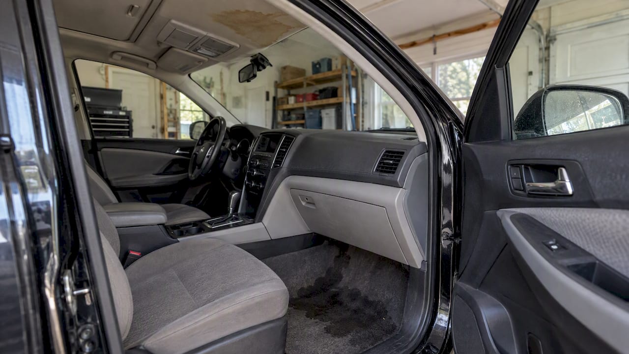 Water-damaged carpet beneath a stained headliner